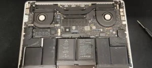 Apple MacBook åbnet med støvede blæsere og bundkort