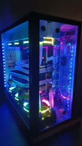 High-end gaming computer med custom loop vandkøling og RGB belysning i mørke