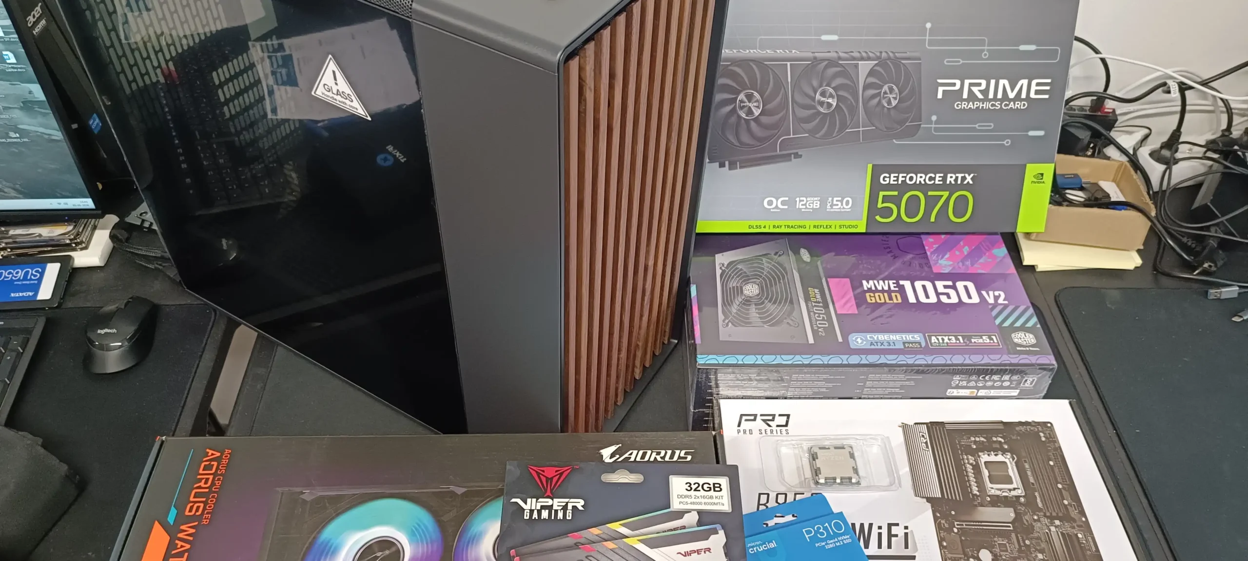 Gaming computer kabinet og hardware komponenter på arbejdsbord.